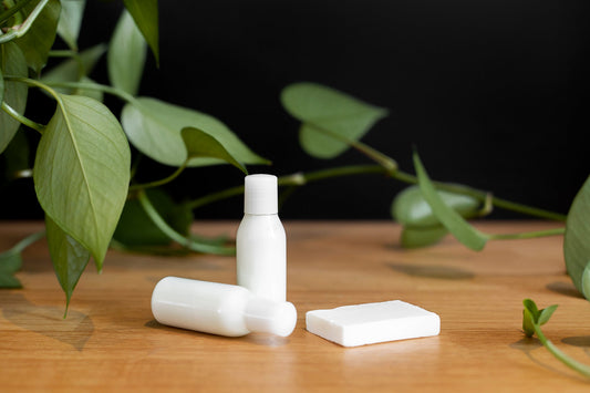 Skincare bottles and green leaves, representing vitamin C skincare products.
